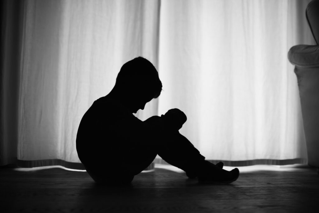 Sad lonely silhouette child sitting at home