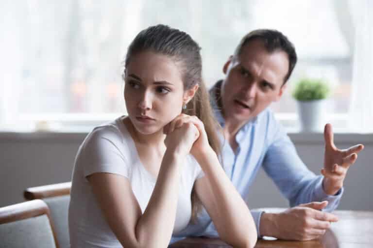Offended woman sitting back to lover looking away avoiding talking, millennial couple having serious fight, mad man screaming or lecturing wife, stubborn female not ready to compromise or reconcile